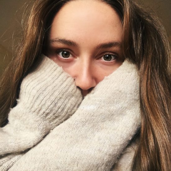 half face selfie mouth covered with hands sweater