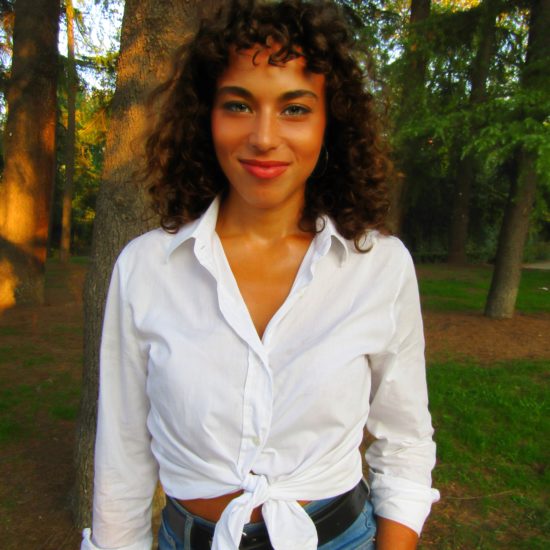 A woman with a white shirt on a forest background with a filter