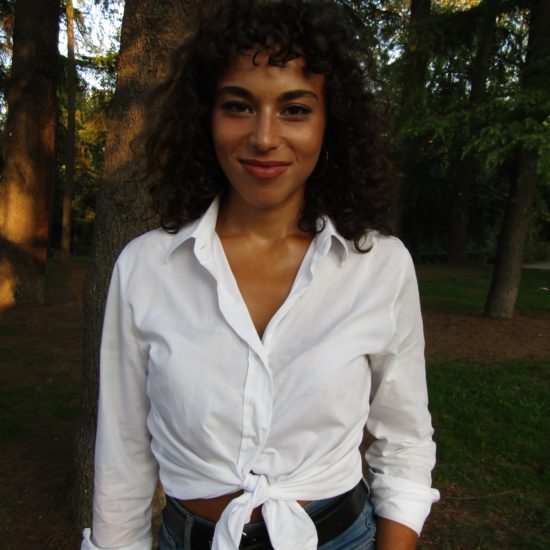 A woman with a white shirt on a forest background