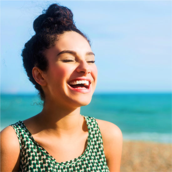 Smiling woman with white teeth against the background of the sea