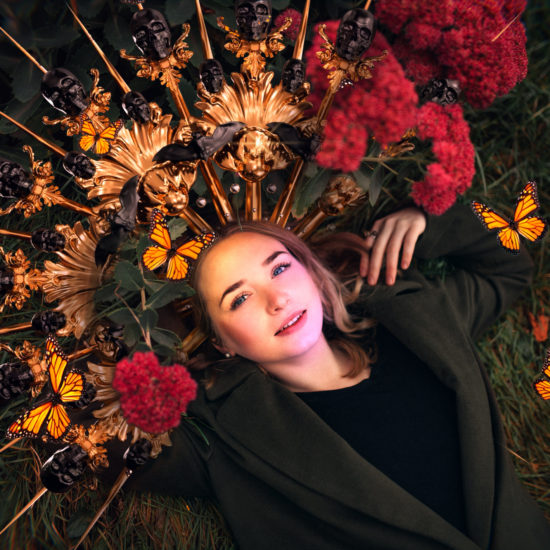 A woman is lying on the grass with  red flowers 