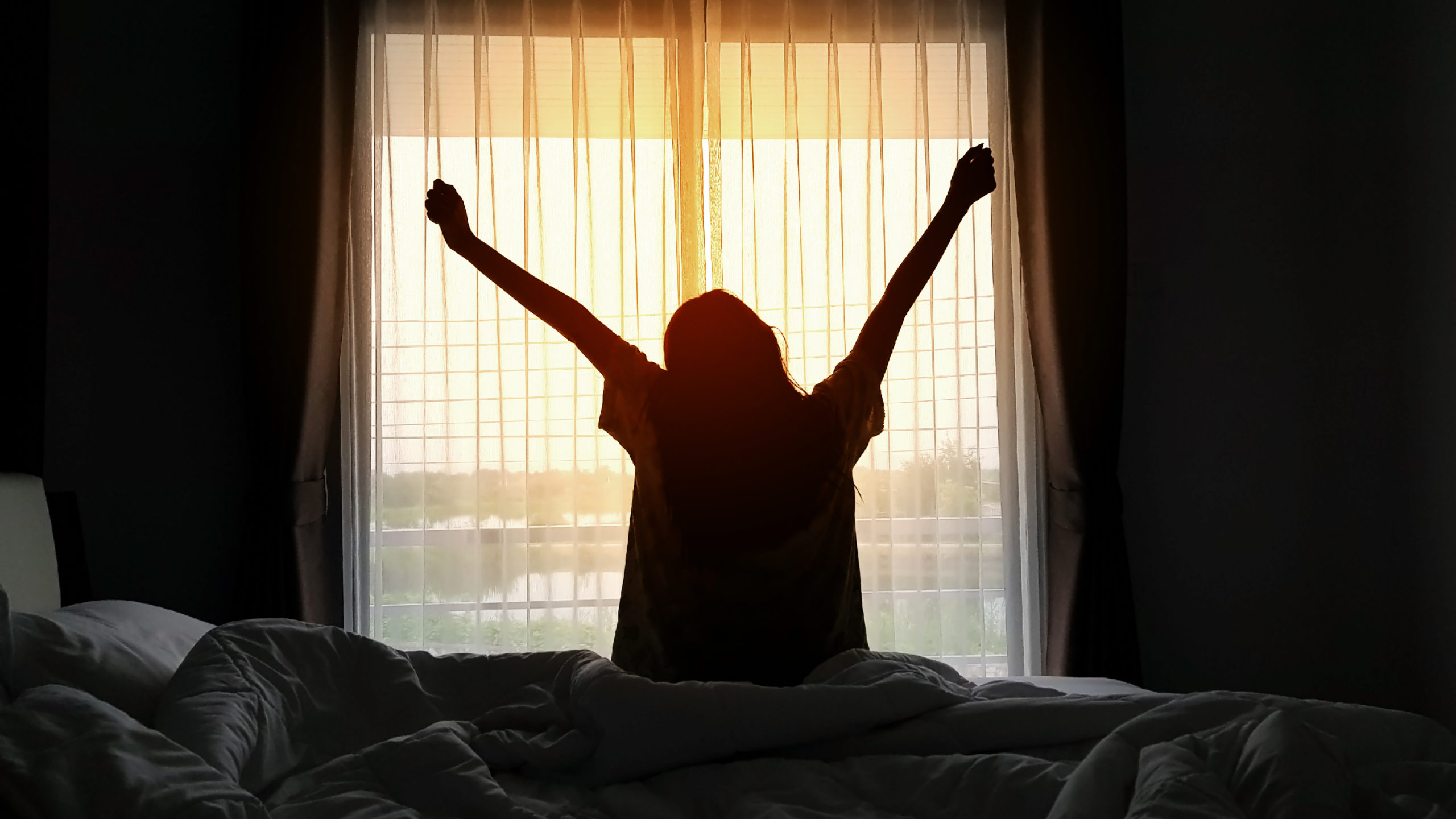 Silhouette Woman Stretching Hands While Sitting On Bed_Cover Photo