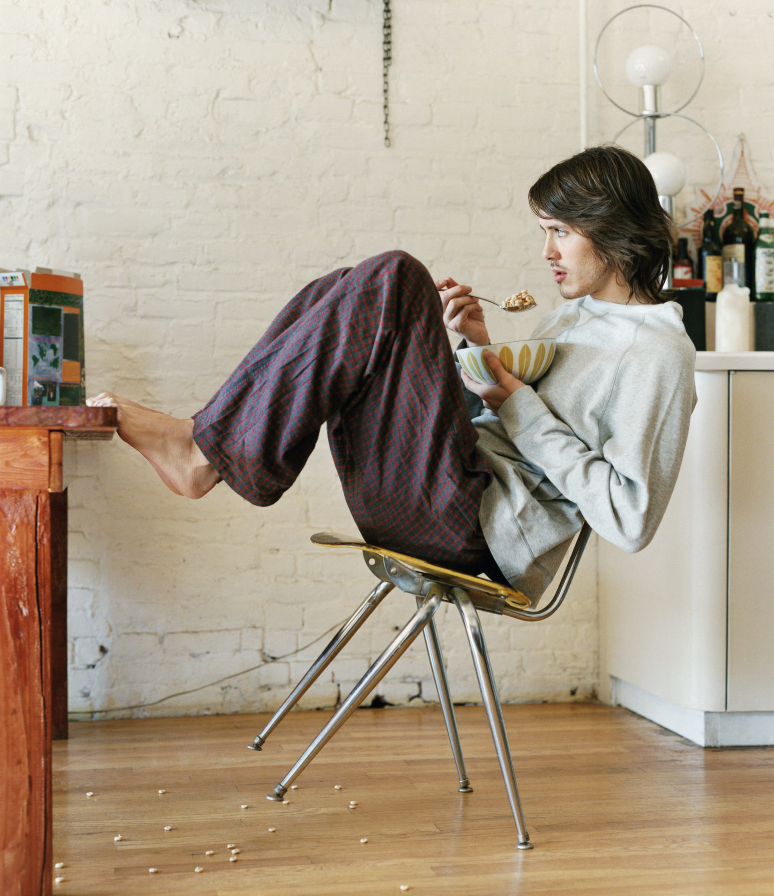 Man in kitchen eating breakfast_bad posture_cover image||woman doing yoga in front of the sea|young man on the couch using his phone