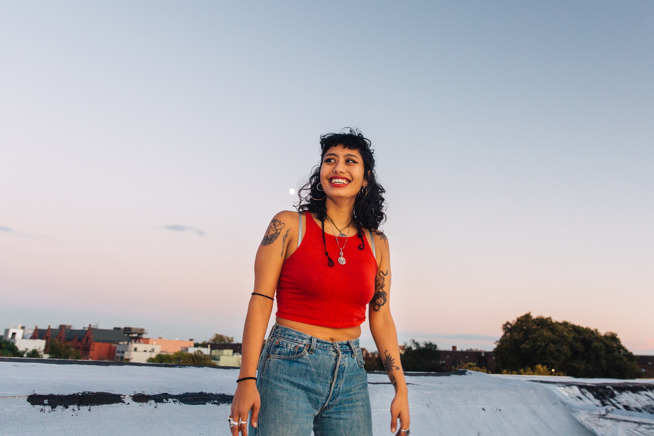 A woman in a red tank top is smiling at the camera