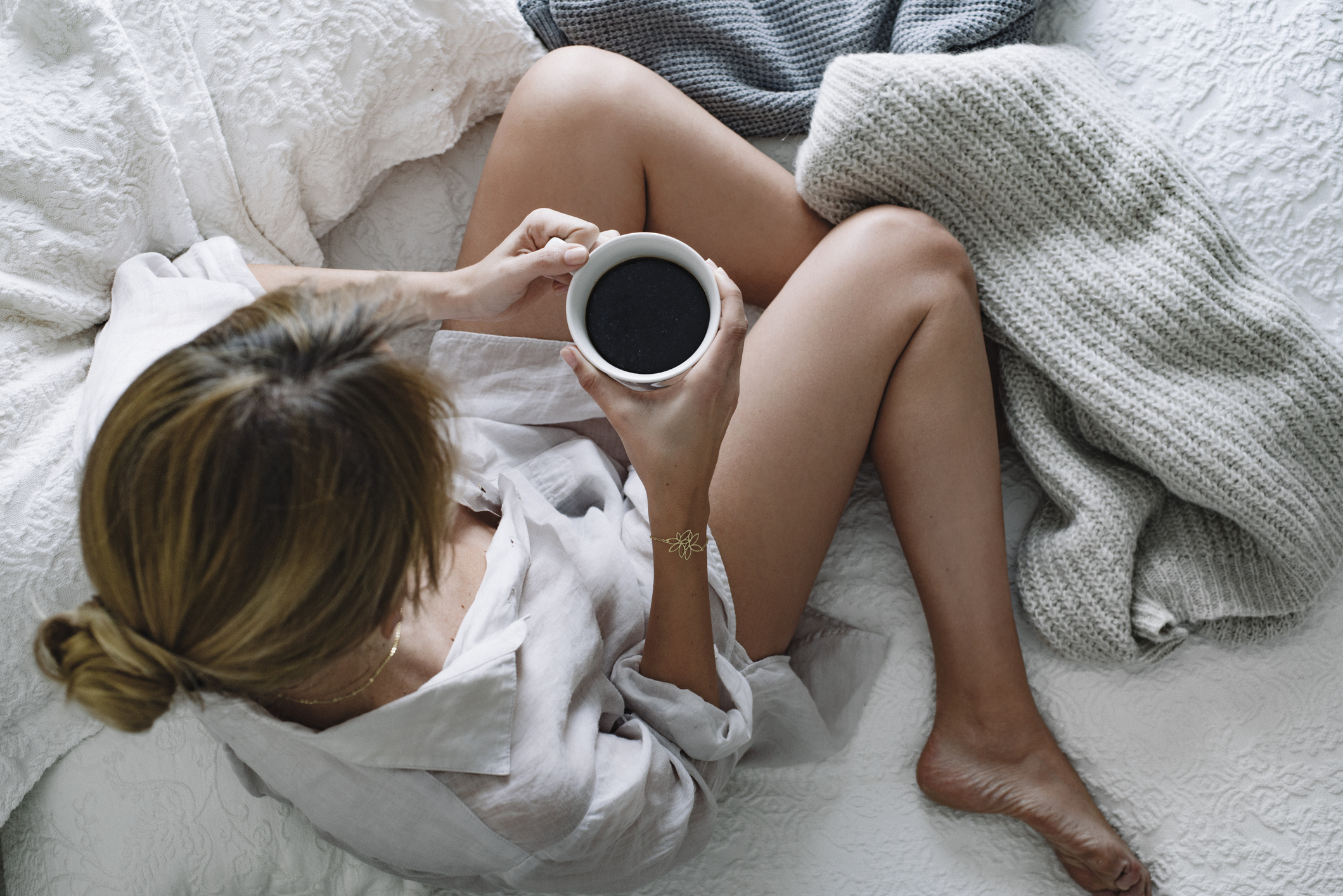 A girl is sitting on a sofa with coffee