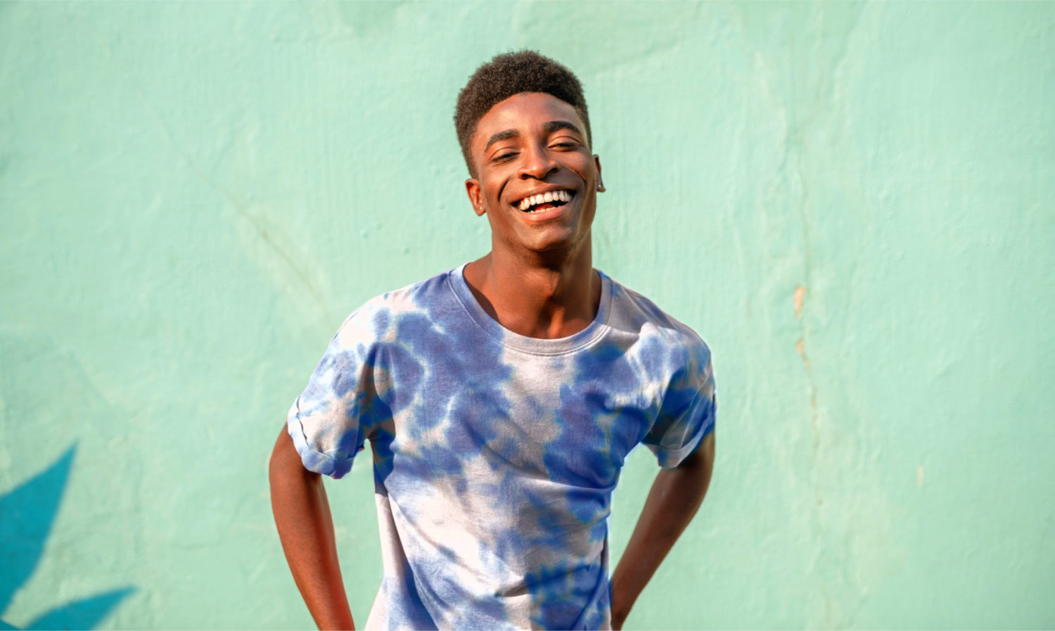 A smiling man with a tulip shirt on a green background