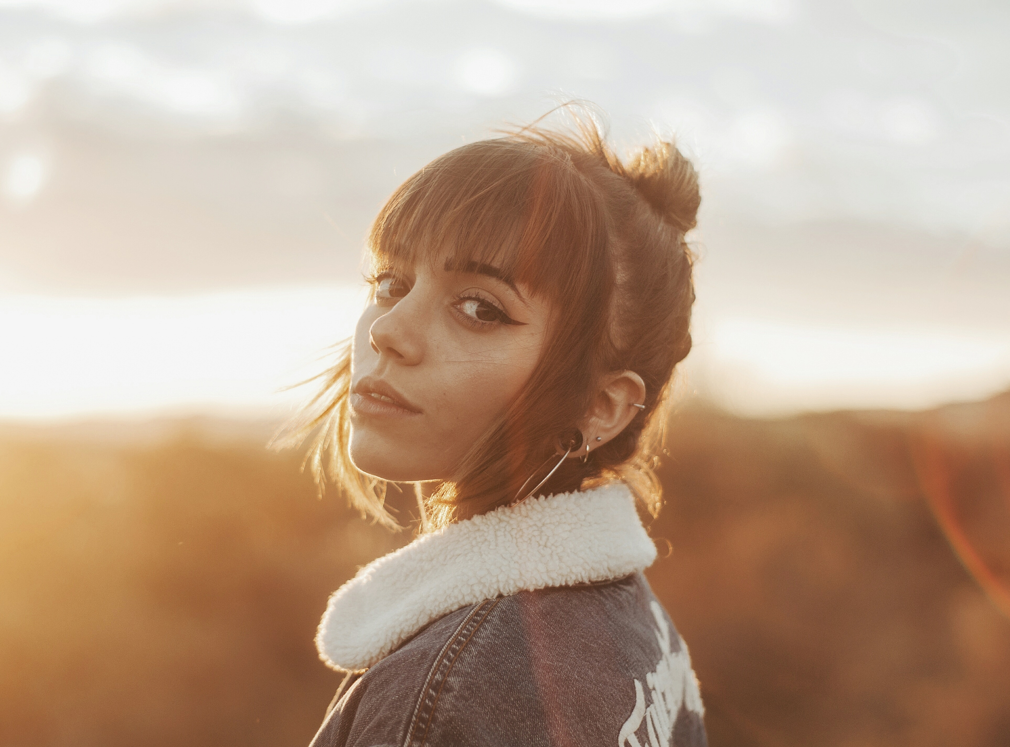 A woman with a jacket on a sunset background