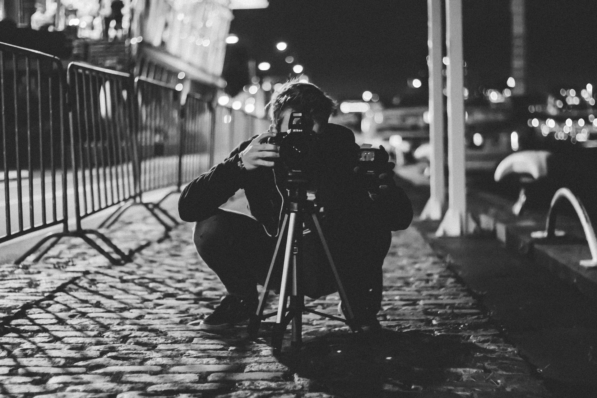 A man looks at the camera in the middle of the street at night