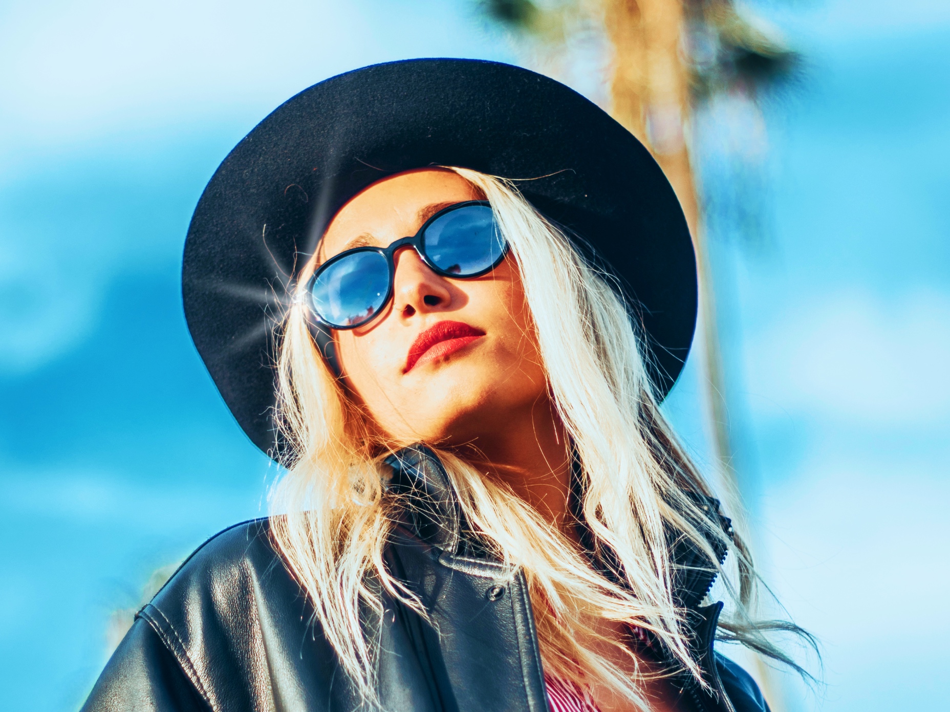 Blonde girl with sunglasses and a black hat
