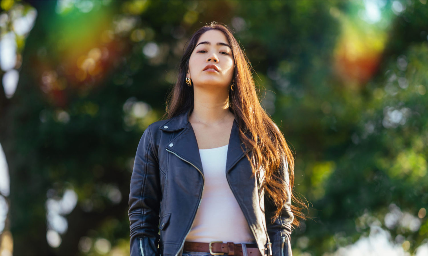 A woman poses with a white shirt and a blue jacket