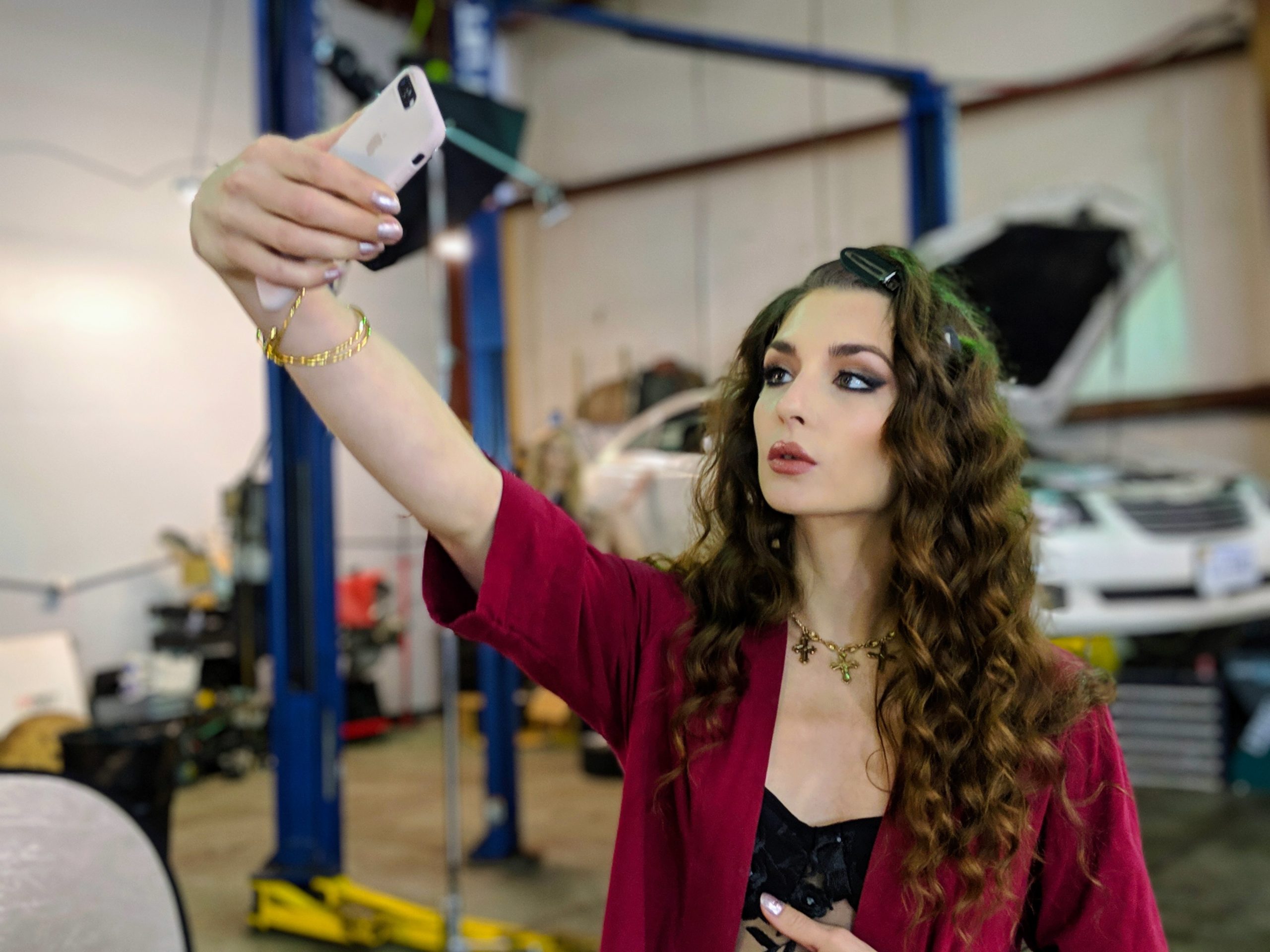 A woman takes a selfie in a car garage