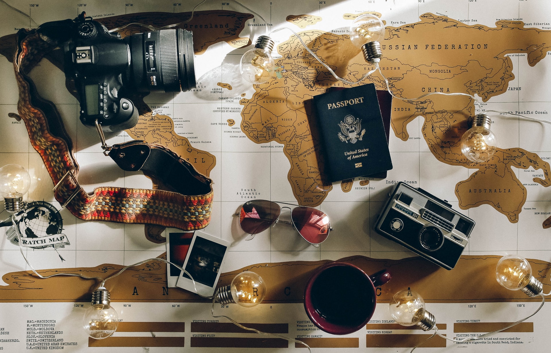Travel photography hashtag: camera and passport on map background.
