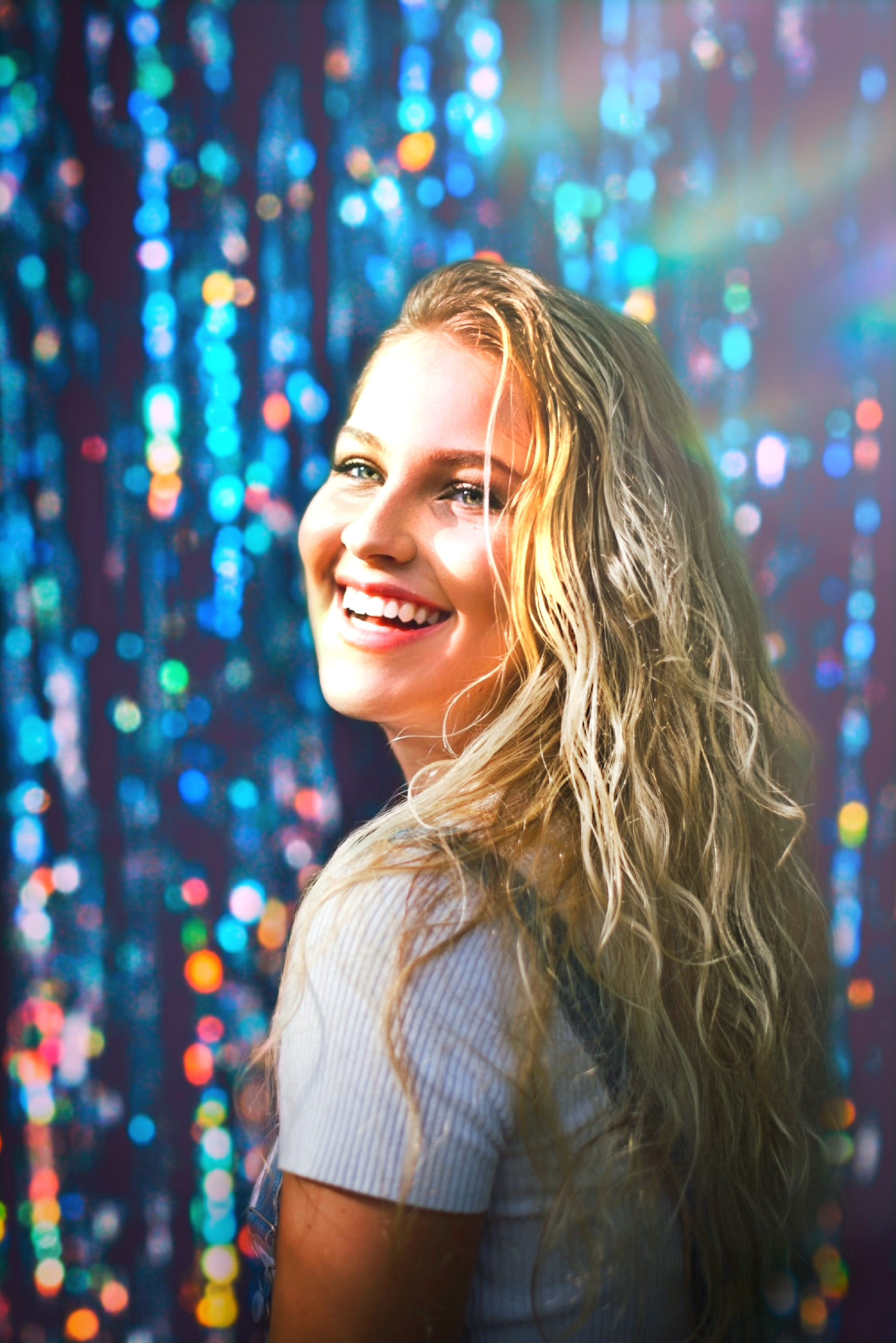 A person takes a selfie with a glittering background