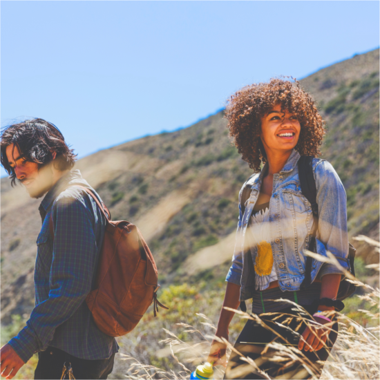 A man and a woman are walking in nature