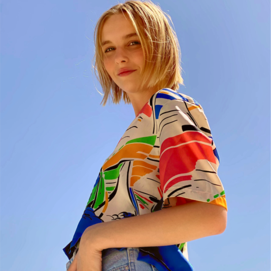 A woman with blond hair and a colorful shirt with a filter