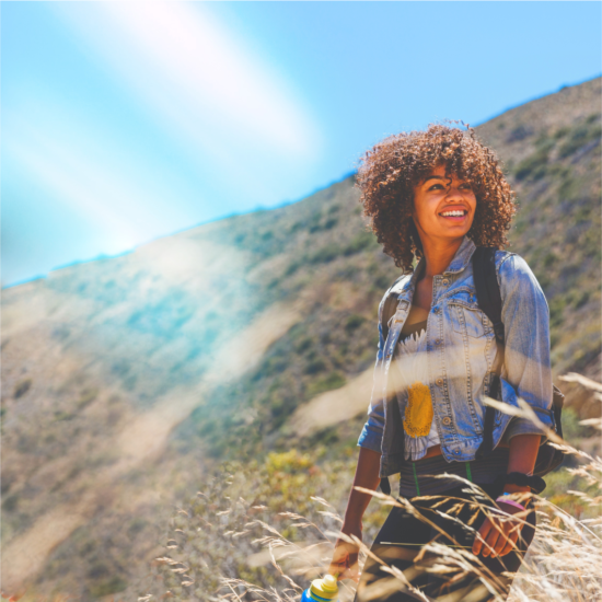 A woman with a denim jacket walks in nature